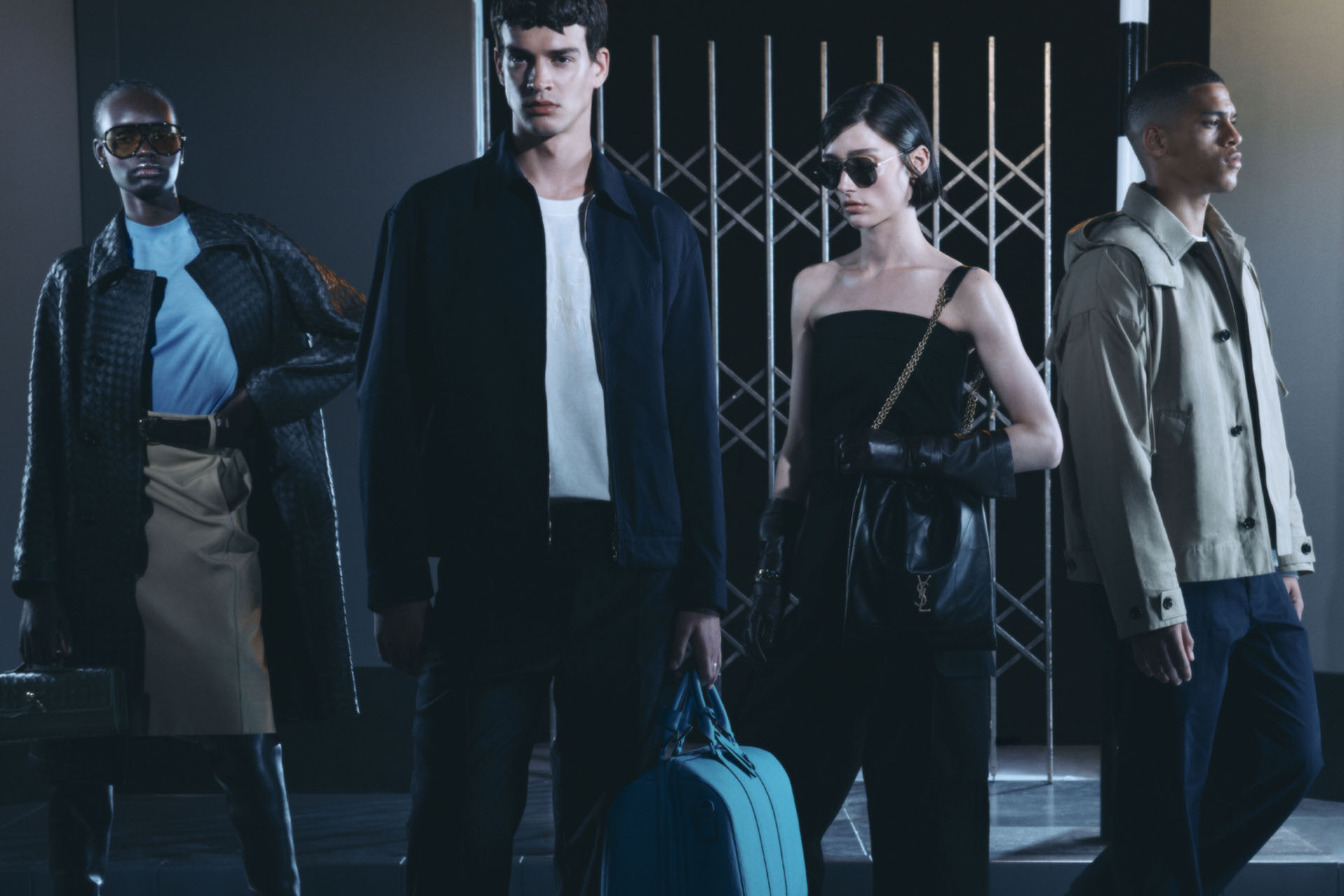 Four models stood in front of a metal gate